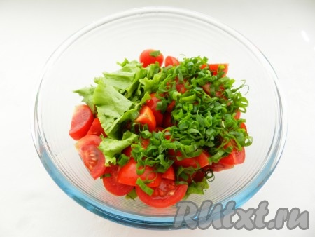 Салатные листья порвать руками и сложить в салатницу. Добавить нарезанные помидоры черри и мелко порубленный зелёный лук.

