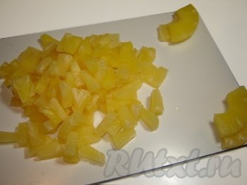 Ананасы достать из банки и нарезать кубиками. 1–2 кружочка ананаса можно оставить для украшения салата.
