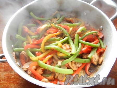 Влить соевый соус, перемешать, накрыть сковороду крышкой и готовить шампиньоны с овощами и стручковой фасолью на медленном огне 2-3 минуты.