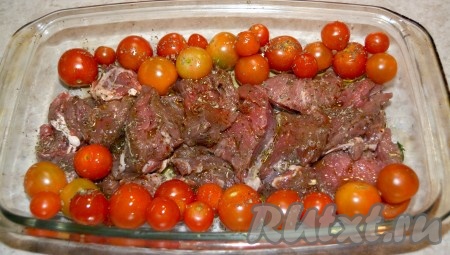 В форму для запекания выложить кусочки мяса, вокруг разместить помидоры. Помидоры также посолить и обсыпать специями. Так как мясо мы смазали маслом, то форму предварительно можно не смазывать.