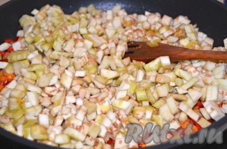 Баклажаны очистить от кожуры, нарезать мелким кубиком и отправить в сковороду к овощам.