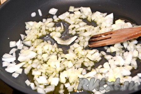 Налить в сковороду растительное масло и в нем обжаривать лук 2 минуты, помешивая, чтобы не подгорел.