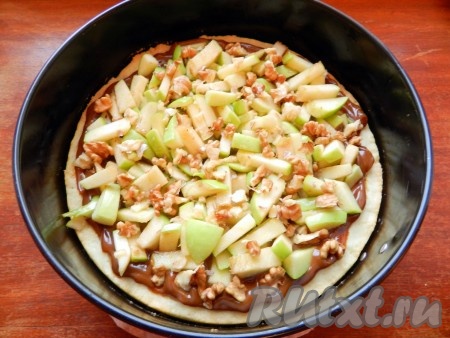 Сверху выложить яблоки, полить образовавшимся яблочным соком. Также можно добавить грецкие орехи, порубленные крупно. Яблочный пирог с варёной сгущёнкой поставить в духовку на 40-45 минут и выпекать при той же температуре.