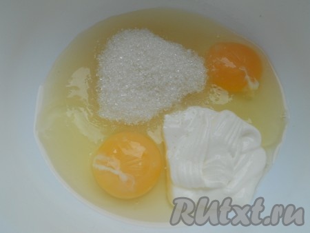 В глубокую миску вбить яйца, добавить сметану и сахар.