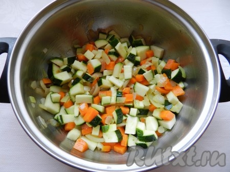 В кастрюле с толстым дном разогреть растительное и сливочное масло.  Обжарить сначала лук и морковь до прозрачности, затем добавить цуккини и обжарить все вместе.