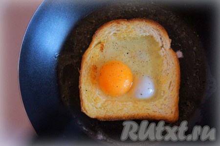 Разбейте яйцо, чтобы оно оказалось внутри "хлебной рамки", посолите, поперчите и готовьте на медленном огне при накрытой крышке около 1-3 минут (время приготовления зависит от того, какую степень приготовления яйца вы любите больше).