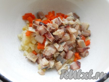Если в филе сельди есть косточки, их нужно вынуть. Филе сельди нарезать на небольшие кубики, добавить в миску с картошкой и морковкой.
