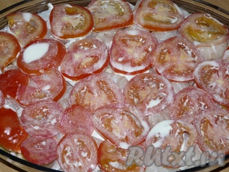  Затем выложить помидоры. В сливки добавить соль, перец и специи для рыбы (специи по желанию). Залить запеканку сливками.
