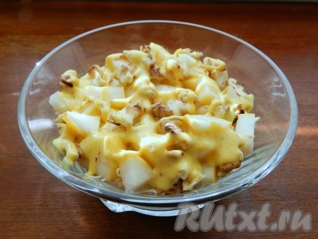 Затем снова выложить слой сыра, груши и орехов. Полить заправкой. 