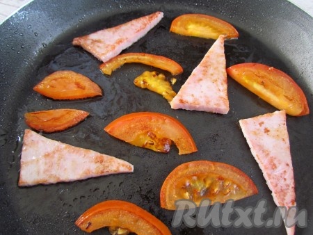 На той же сковороде, на которой жарились грибы, обжарьте с двух сторон помидоры и ветчину.