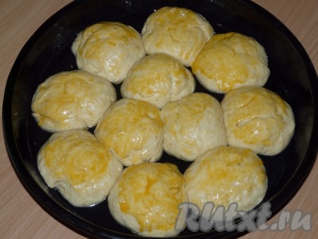  Подошедшие булочки смазать взбитым яичным желтком. Поставить булочки в заранее разогретую духовку и выпекать при 200 градусах примерно 25-30 минут.