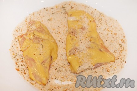 Нарежьте куриное филе на тонкие порционные кусочки и обваляйте в горчице, а затем в подготовленной панировке со специями.