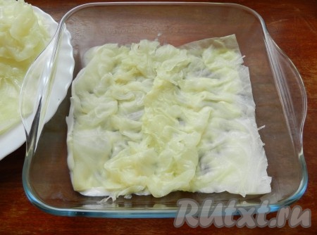 В форму для запекания выложить немного соуса бешамель. Сверху разложить капустные листья в один слой.