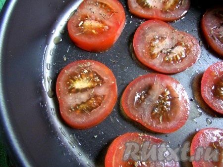 Помидоры вымойте, просушите и нарежьте кружочками. Форму для запекания или противень смажьте оливковым маслом. Выложите нарезанные помидоры, посолите, посыпьте сухим базиликом и запекайте в духовке около 10 минут при температуре 200-210 градусов.