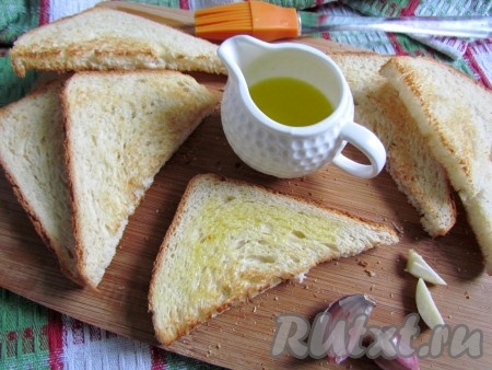 Хлеб для тостов разрежьте по диагонали на две части и подсушите на сухой горячей сковороде или в тостере. Горячие тосты натрите чесноком и смажьте оливковым маслом.