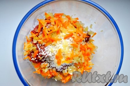 Лук и морковь измельчить, обжарить на оливковом масле (3-5 минут на умеренном огне). В фарш добавить промытый рис, половину зажарки, соль, перец, 2 измельченных чубчика чеснока.
