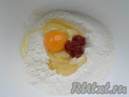 Теперь тесто: муку просеять в глубокую миску, сделать углубление, добавить соль, яйцо, томатную пасту и оливковое масло.