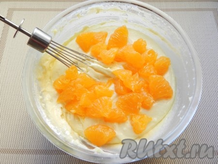 Дольки мандарина разрезать пополам, слить образовавшийся сок, а кусочки мандарина добавить в тесто. Аккуратно перемешать.