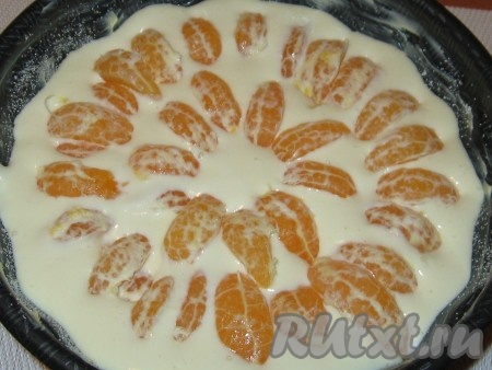 Дольки мандарина выложить сверху, слегка вдавливая в творожную массу, затем форму поставить в заранее разогретую до 180 градусов духовку и выпекать 40-45 минут.
