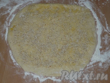 Разделить дрожжевое тесто на две части (у нас получится две плетёнки). Раскатать тесто  в пласт, смазать растопленным сливочным маслом и посыпать кунжутом.
