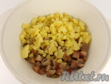 Картошку вымыть и, не очищая от кожуры, отварить до готовности (на варку потребуется минут 20-25, готовые картошины должны легко прокалываться вилкой). Отдельно сварить в кожуре свеклу (на варку, в зависимости от размера и сорта свеклы, потребуется от 50 до 70 минут). Отварить яйца в течение 9-10 минут с момента закипания воды. Варёные картошку, яйца и свеклу остудить и очистить. Зелень вымыть. Если в филе сельди есть косточки, их нужно убрать. Картошку и селёдку нарезать на средние кубики, выложить в достаточно глубокую миску.