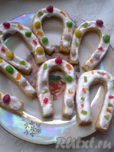 Готовое печенье "Счастливая подкова" смазываем глазурью и украшаем цукатами и морскими камешками.