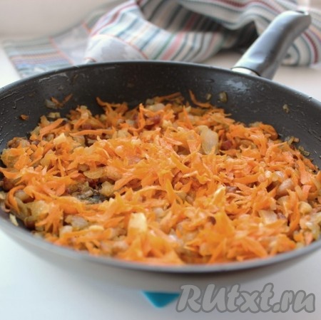 К луку выложить натёртую морковь, обжаривать овощи 4-5 минут (до мягкости морковки), периодически перемешивая.