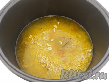Влить горячую воду, посолить по вкусу. Добавить порезанный чеснок и лавровый лист.