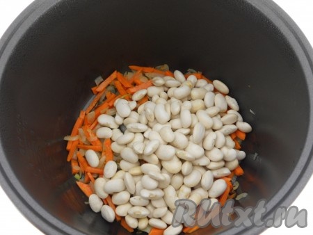 После того как овощи обжарятся, добавить фасоль и влить 1 столовую ложку растительного масла.