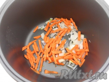 В чашу мультиварки влить растительное масло, выложить лук и морковь. Выставить режим "Обжаривание" на 10 минут.
