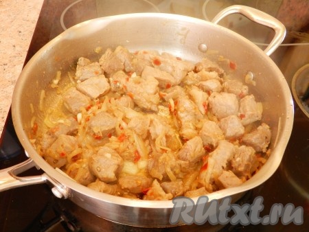В сковороде разогреть растительное масло и обжарить мясо с луком до золотистого цвета. Добавить мелко нарезанный чеснок, обжарить еще 1 минуту.
