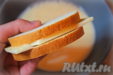 Отрежьте 2 кусочка сыра размером с ломтик батона (или чуть больше) толщиной 4-5 миллиметров. На сковороде растопите сливочное масло. На один ломтик батона положите кусочек сыра, накройте вторым ломтиком батона, получится бутерброд, как на фото.