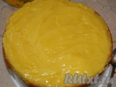 Смазать нижний корж торта лимонной начинкой.
