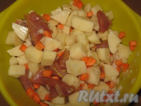 Картофель очистить и нарезать на средние кубики. Затем кусочки свинины соединить с морковью, картошкой и луком, добавить пропущенный через пресс чеснок, перемешать.