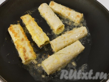 Сливочное масло разогреть на сковороде, добавить несколько кусочков чеснока. Каждую трубочку обмакнуть во взбитые яйца. Обжарить со всех сторон до румяной корочки.