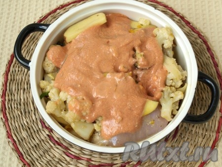 Выложить соус на овощи. Накрыть керамическую форму крышкой и поставить в духовку, включив её на 190-200 градусов. Запекать рагу из курицы и овощей минут 45, проверяя готовность по картошке.
