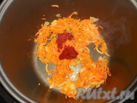 В чашу мультиварки влить растительное масло, добавить порезанную вторую луковицу и натертую на крупной терке морковь. Выставить режим "Обжаривание" на 15 минут. Затем добавить томатную пасту, влить грамм 100 горячей воды, перемешать.
