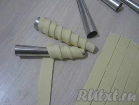 Металлические конусы протираем бумажной салфеткой, пропитанной растительным маслом. Каждую полоску теста накручиваем спиралью, начиная с узкой стороны конуса, внахлёст 3-4 мм.

