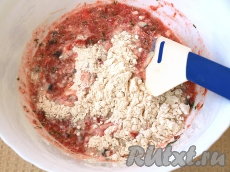 Добавляем муку, просеянную с разрыхлителем, и тщательно перемешиваем тесто для приготовления оладьев из помидоров.

