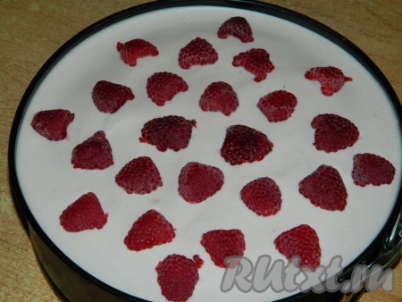 На застывший торт выкладываем ягоды малины.