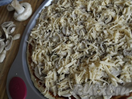 Пиццу "Регина" посыпаем натёртым сыром и ставим в духовку, разогретую до 220 градусов, на 10-12 минут.
