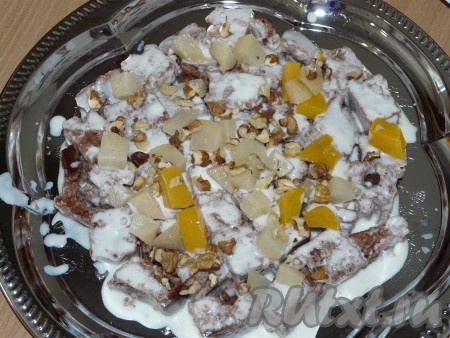 Собрать торт. Ломтики бисквита окунать в сметану и хаотично укладывать на тарелку, добавить фрукты и орехи. 