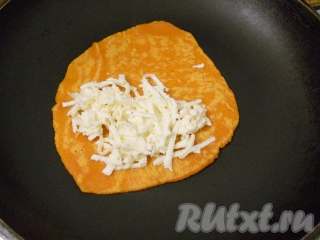 На сухую, хорошо разогретую сковороду выложить лепешку. Жарить на среднем огне около 1 минуты, после чего перевернуть на другую сторону и разложить на одной стороне тертый сыр.