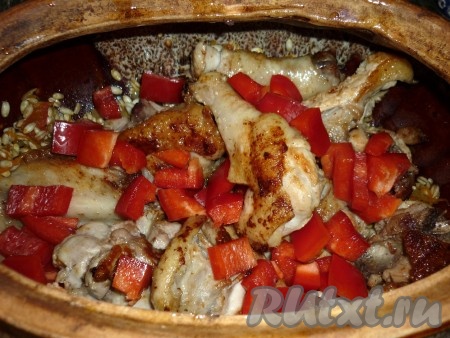 Болгарский перец режем кубиками. На дно горшочка для запекания выкладываем перловку с овощами, затем курицу. Сверху кладём порезанный болгарский перец.
