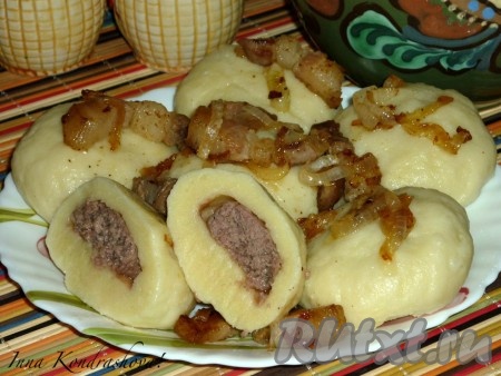 Картофельные галушки с фаршем выкладываем на тарелку и подаём с жаренным луком и салом.

