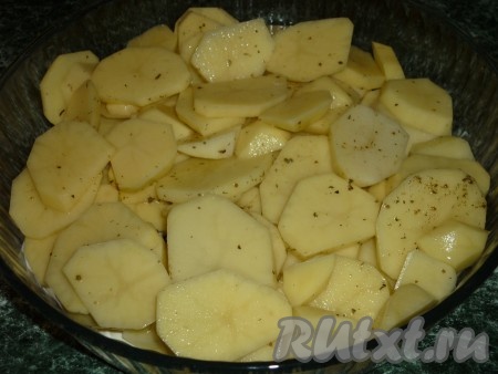 Очищенный картофель режем достаточно тонкими кружками, солим, перчим, выкладываем в жаропрочную форму.
