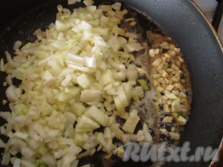 В глубокой сковороде растопите ложку сливочного масла и немного обжарьте на нём измельчённые лук и чеснок.