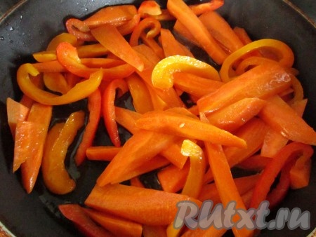 Морковь и сладкий перец очистите и крупно натежьте. В большой сковороде нагрейте растительное масло и слегка обжарьте морковь и перец.