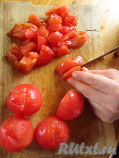 Теперь шкурка с томатов должна легко очиститься. Нарежьте очищенные томаты на кусочки.