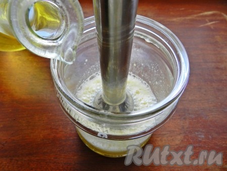 Не останавливая блендер,  тонкой струйкой вливать растительное масло и взбивать массу, пока она достаточно не загустеет. Для этого понадобится 1-2 минуты.